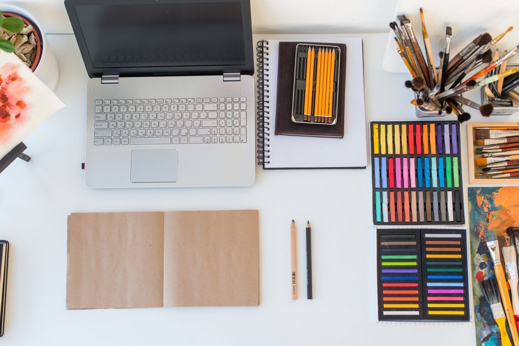 Designer workplace top view. Painter desk with drawing equipment. Home studio for artist.